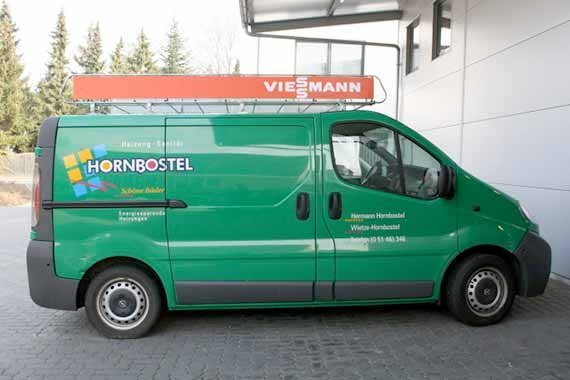 Der Handwerkerwagen von Hornbostel, in leuchtendem Grün, parkt vor einem modernen Gebäude mit einem Viesmann-Schild.