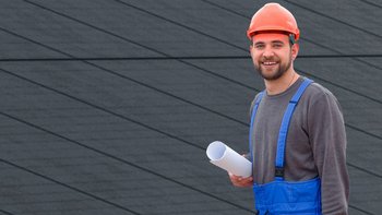 Ein Installatör mit einer Photovoltaikanlage im Hintergrund